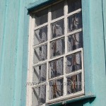 Традиційне віконце зі старими рамами і цілком робочими гратами